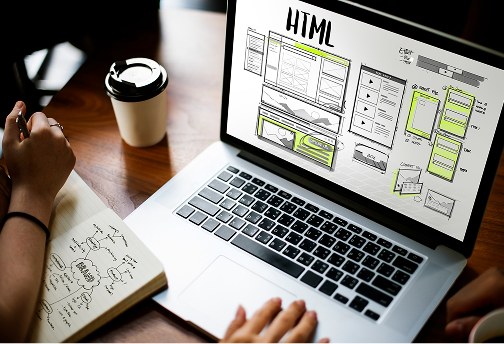 Web development wireframes and code on a laptop